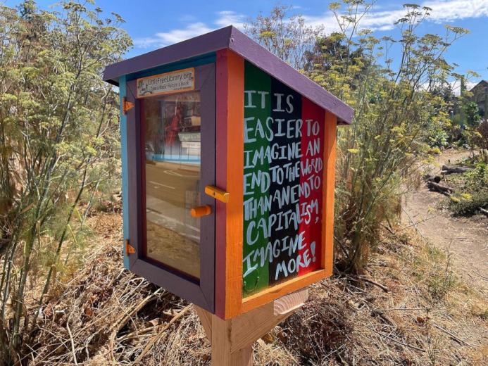 Tiny library box that reads, It is easier to imagine an end to the world than an end to capitalism